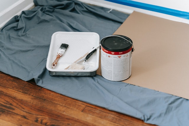 blue%20tarp%20with%20paint%20tray,%20can%20and%20rollers%20the%20prep%20for%20wall%20painting